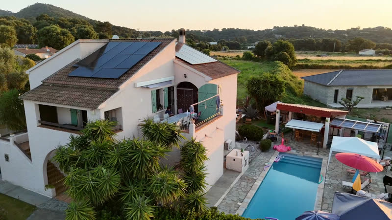 La maison et la piscine au coucher du soleil, vues du ciel