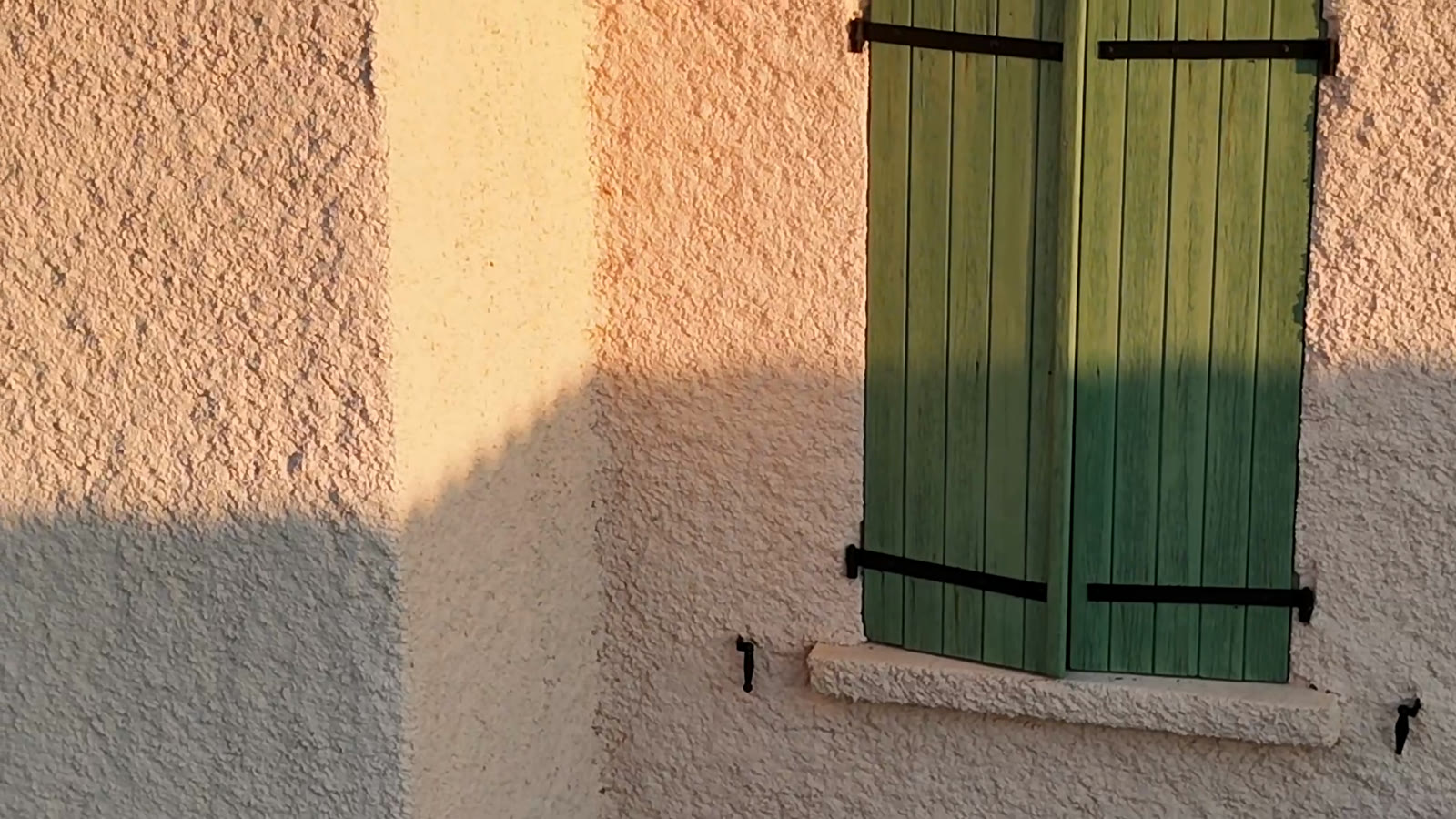 Les volets verts de la maison dans la lumière du soir